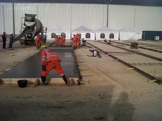 Cuadrilla fundiendo losas de pavimento en concreto
